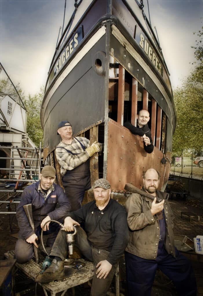 Ambachtslieden van de Koningspoort bij een schip