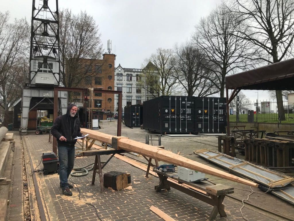 Het maken van een houten mast op de werf