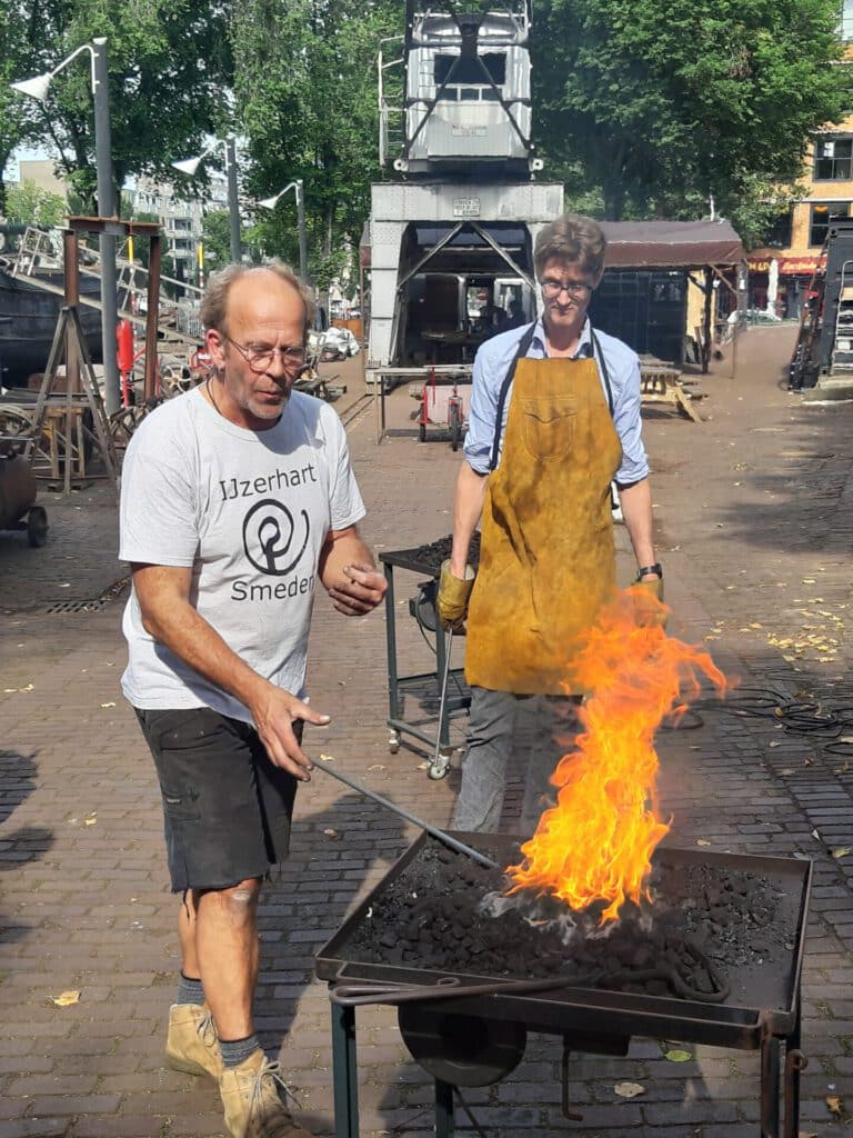 Vrijwilligers aan het smeden op de werf