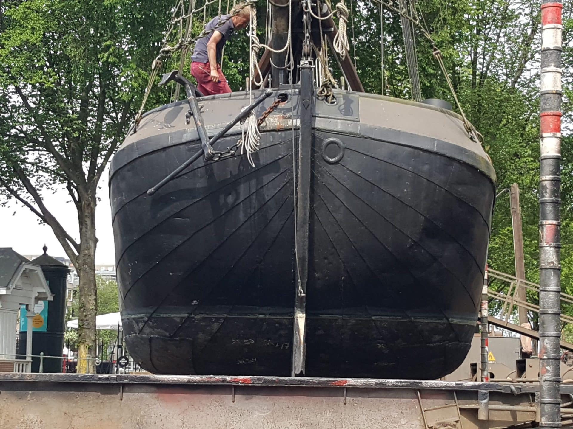 Boeg van een schip op de helling, met een medewerker aan het werk