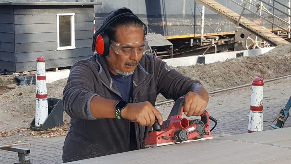 Een vakman schaaft een houten plank