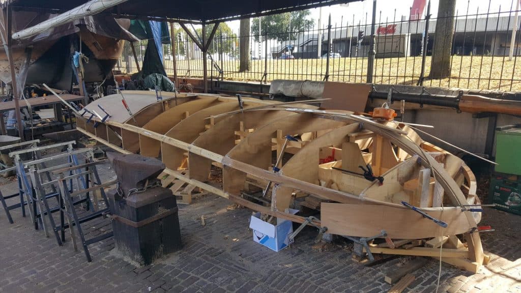 Het geraamte van een houten sloep in aanbouw