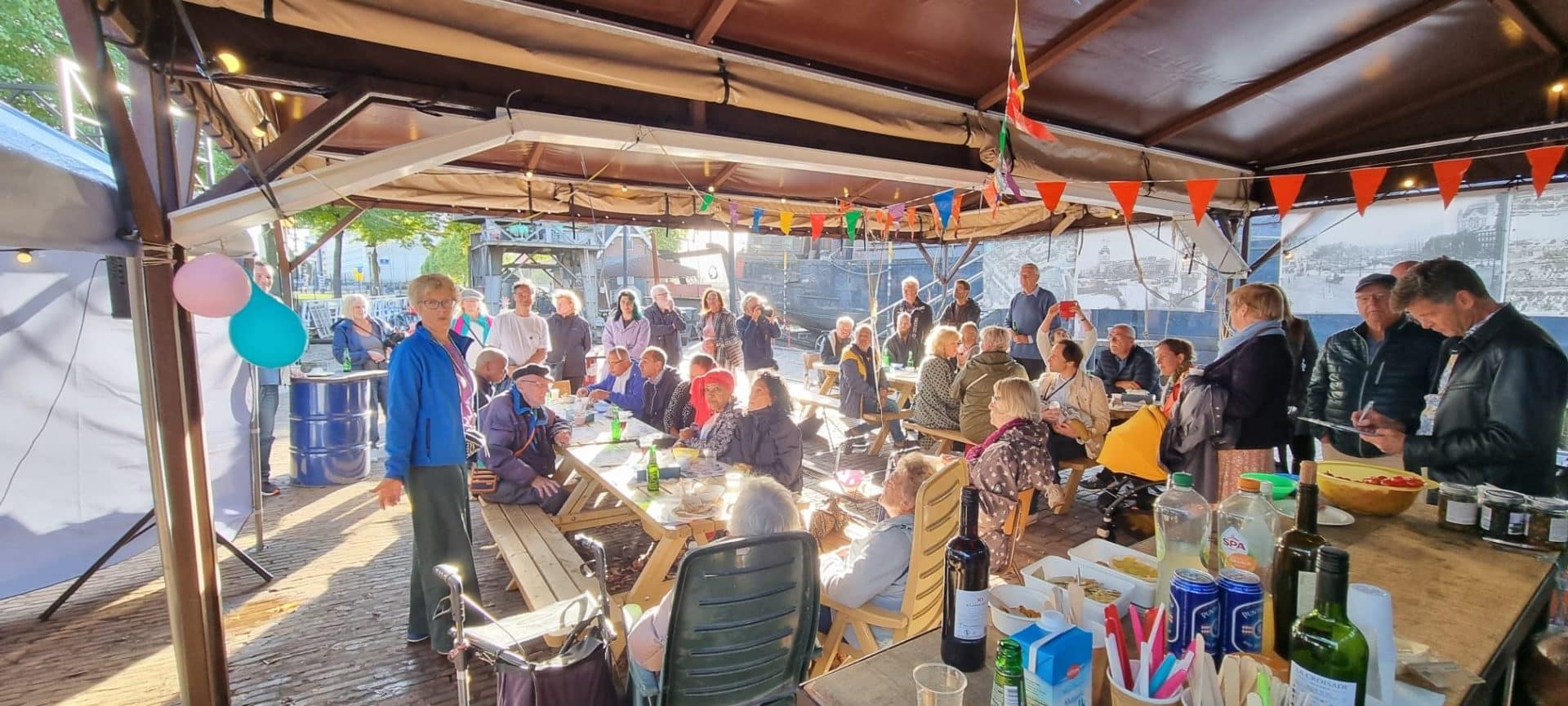 Vrienden-van-de-Koningspoort aan lange tafels onder de tent