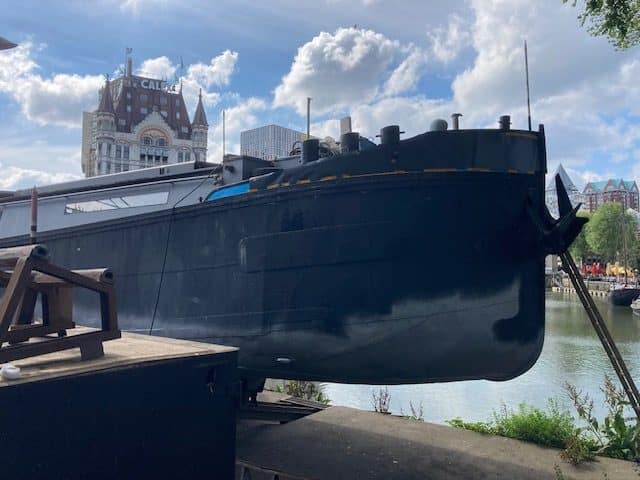 Zwart binnenvaartschip op de helling met het Witte Huis